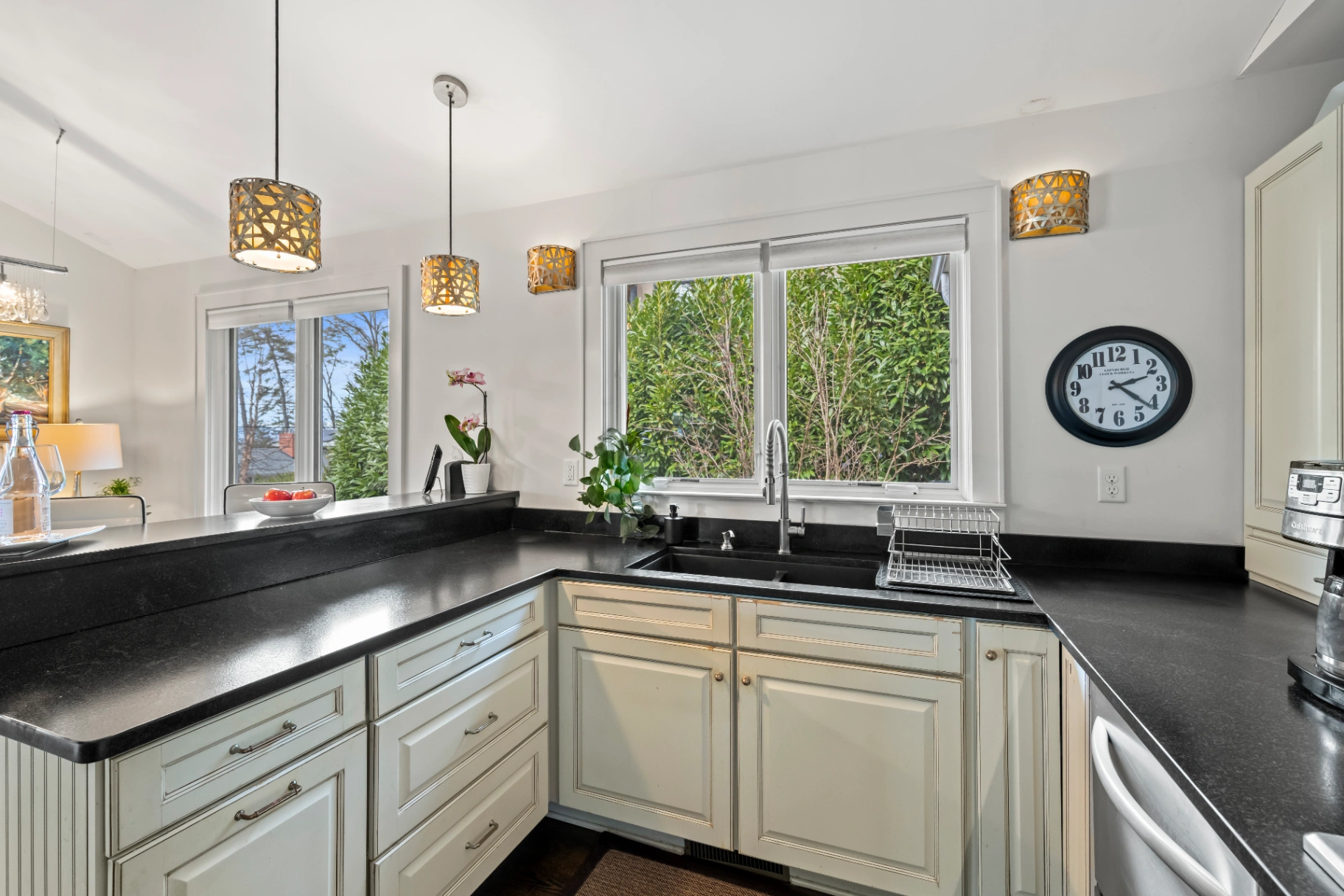 Bright kitchen with black countertops and white cabinets — fully equipped Asheville vacation rental kitchen