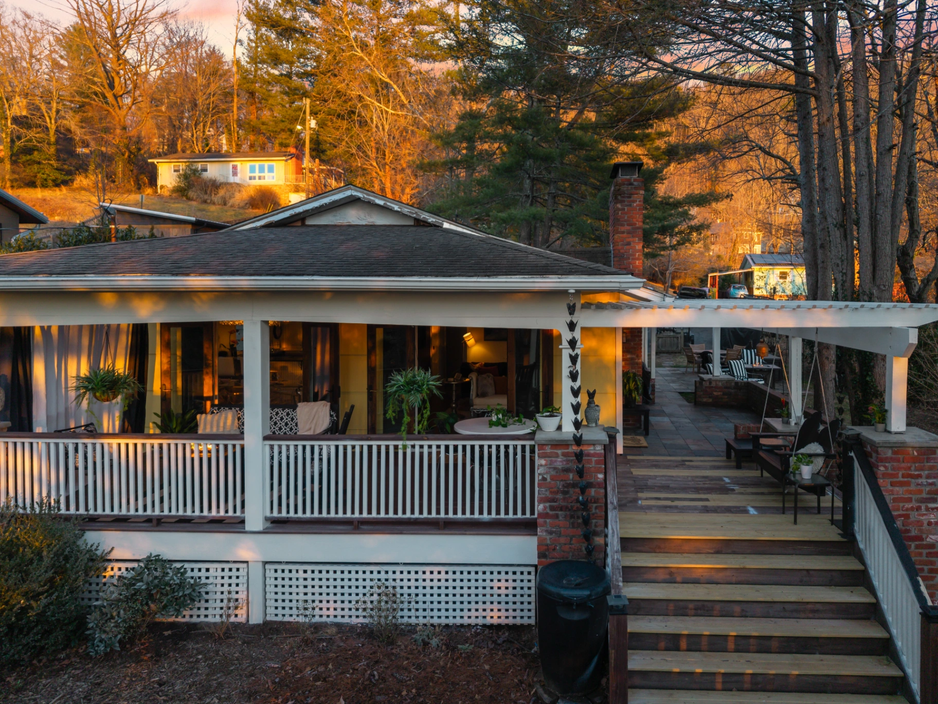 Charming exterior of Asheville Intimate Gatherings vacation rental — covered porch and deck at sunset