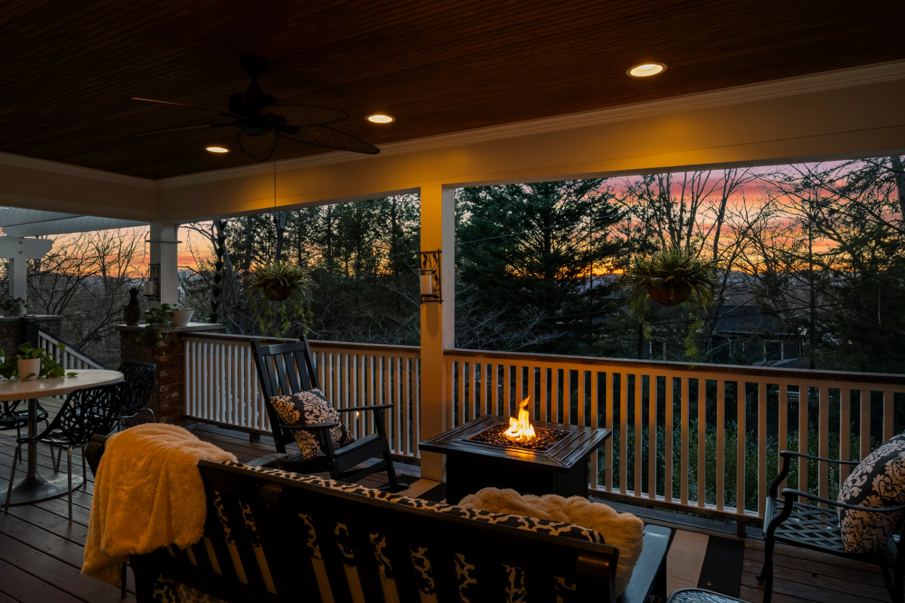 Covered porch with fire pit at sunset — outdoor entertaining space at Asheville rental