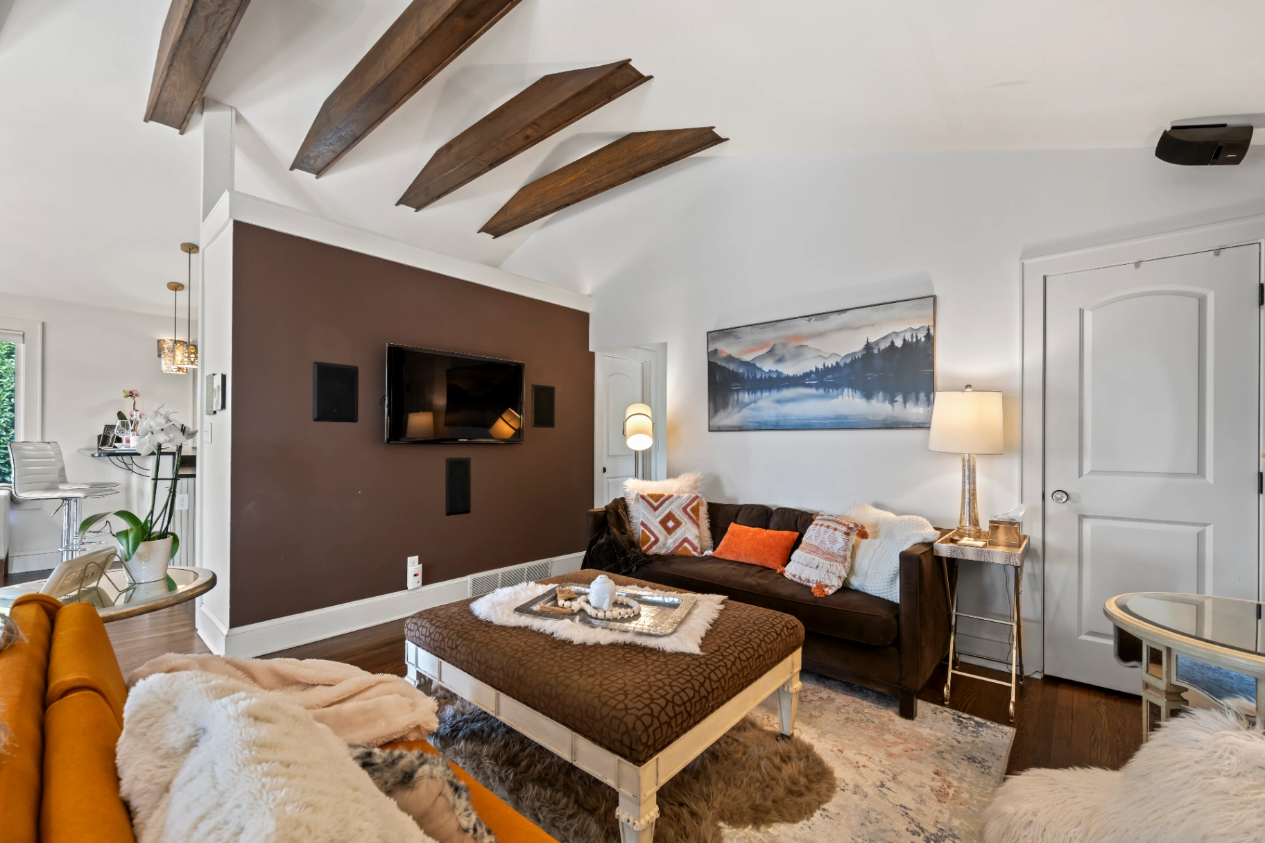 Cozy living room with vaulted ceiling and exposed wood beams — mid-century modern Asheville vacation rental