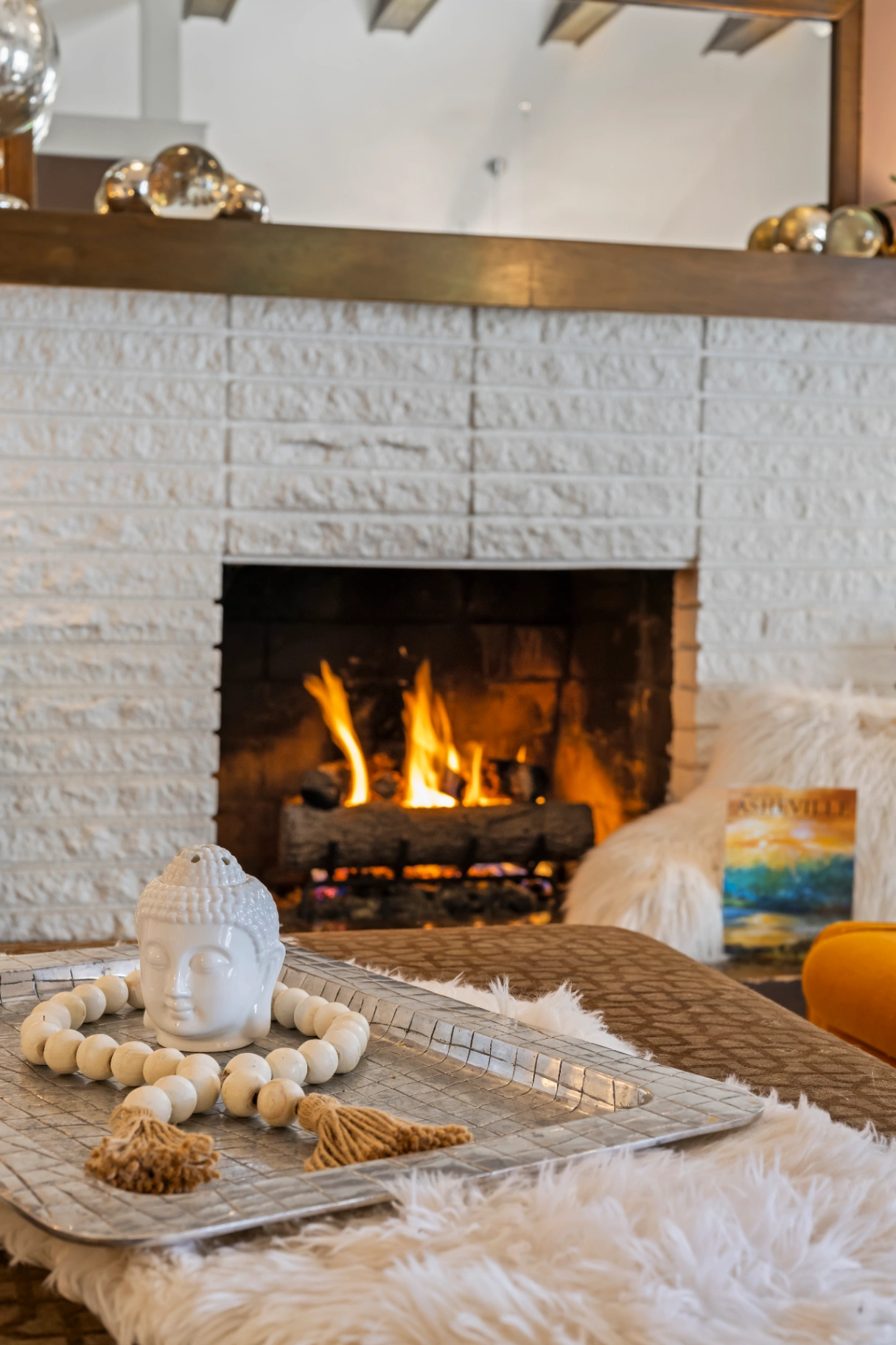 Cozy living room with white brick fireplace and decorative accents — Asheville vacation rental