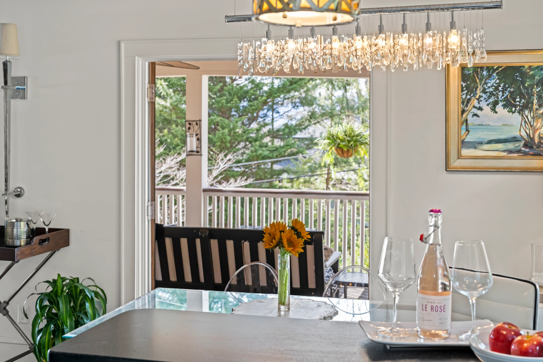 Elegant dining room with crystal chandelier and outdoor balcony view — Asheville vacation rental dining