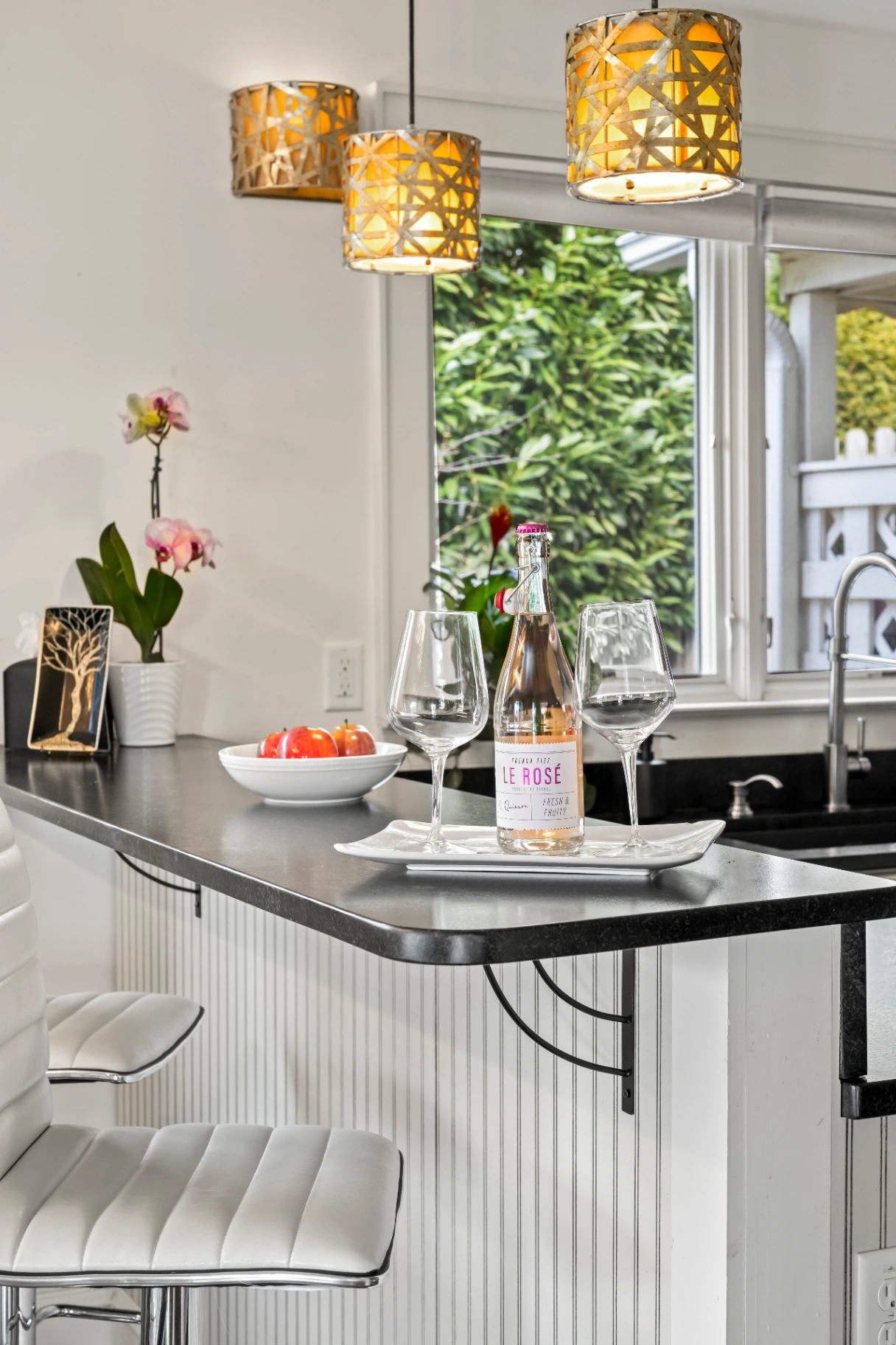 Kitchen breakfast bar with wine glasses and pendant lights — entertaining space in Asheville rental