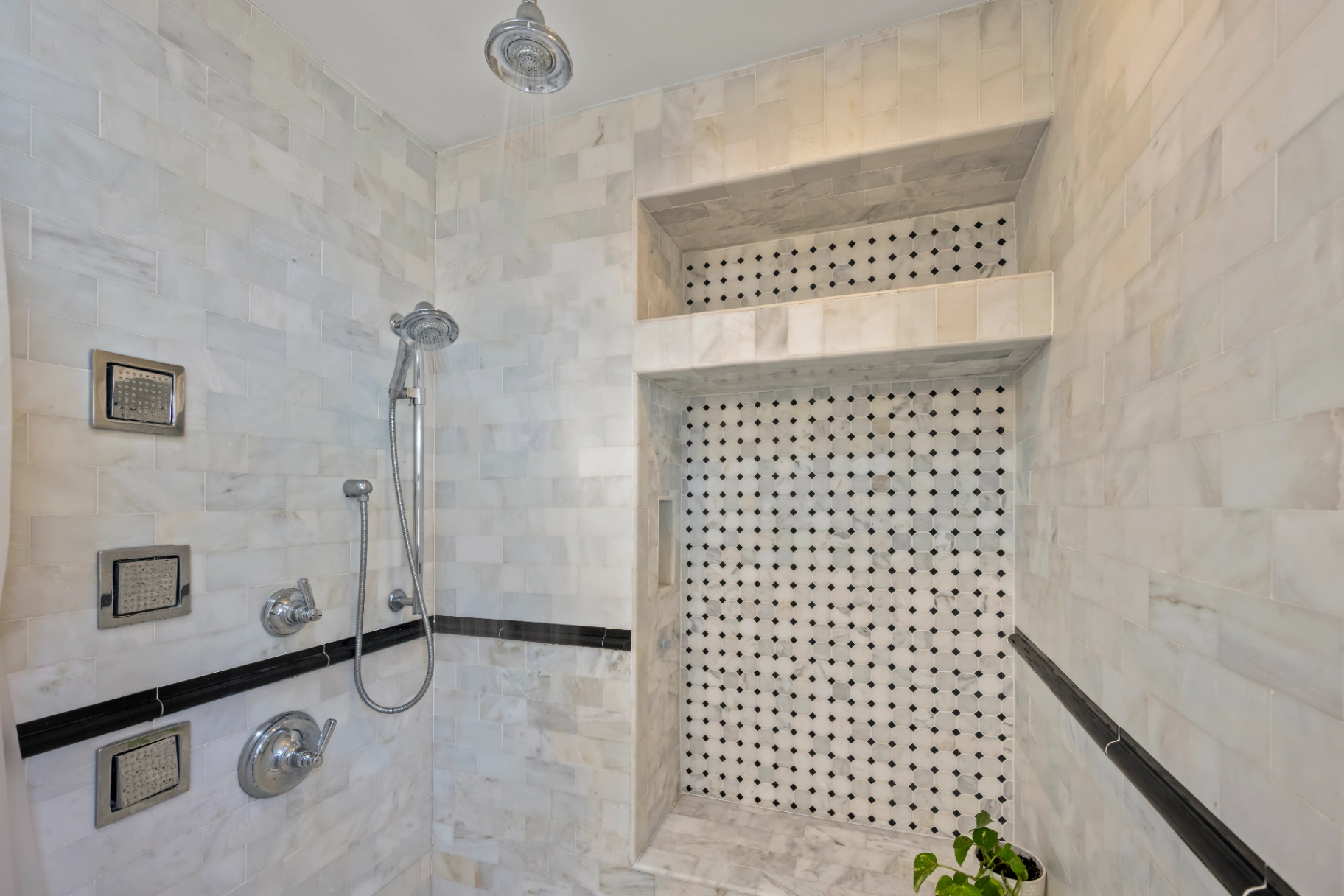 Luxury marble walk-in shower with rain shower head and recessed niche — upscale Asheville vacation rental bathroom