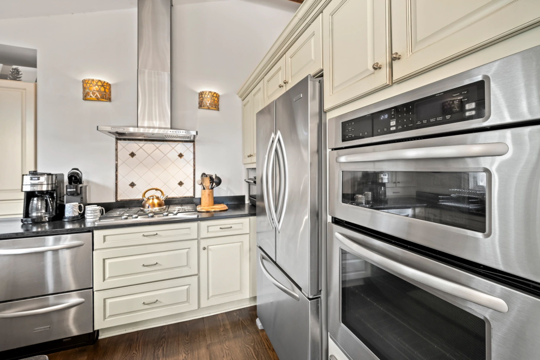 Modern kitchen with stainless steel appliances and cream cabinets — well-stocked Asheville vacation home kitchen