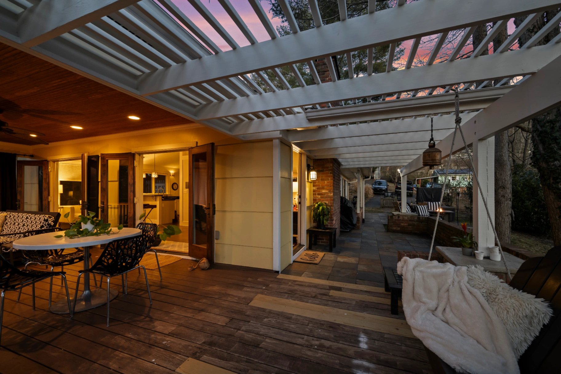 Outdoor patio and deck with white pergola at twilight — Asheville vacation rental evening ambiance