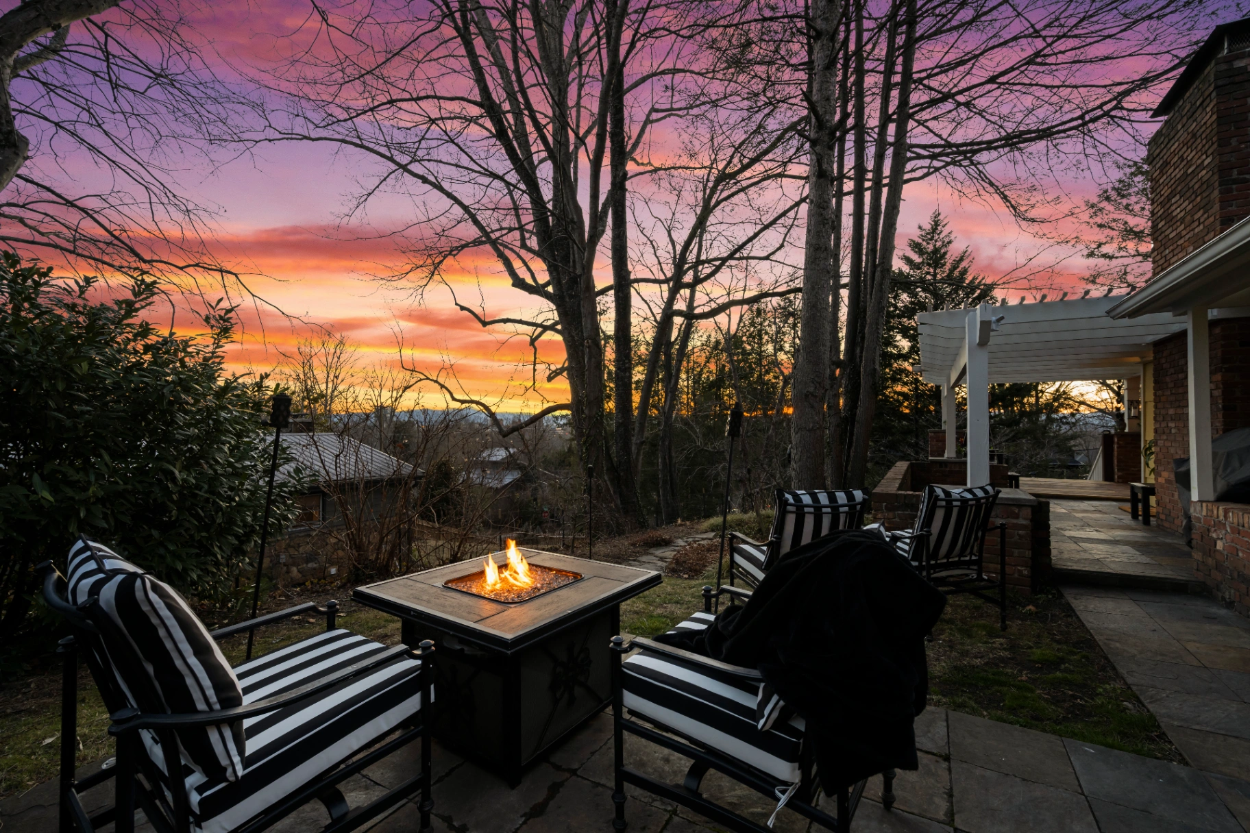 Outdoor patio seating area with fire pit at sunset — Asheville NC vacation rental evening