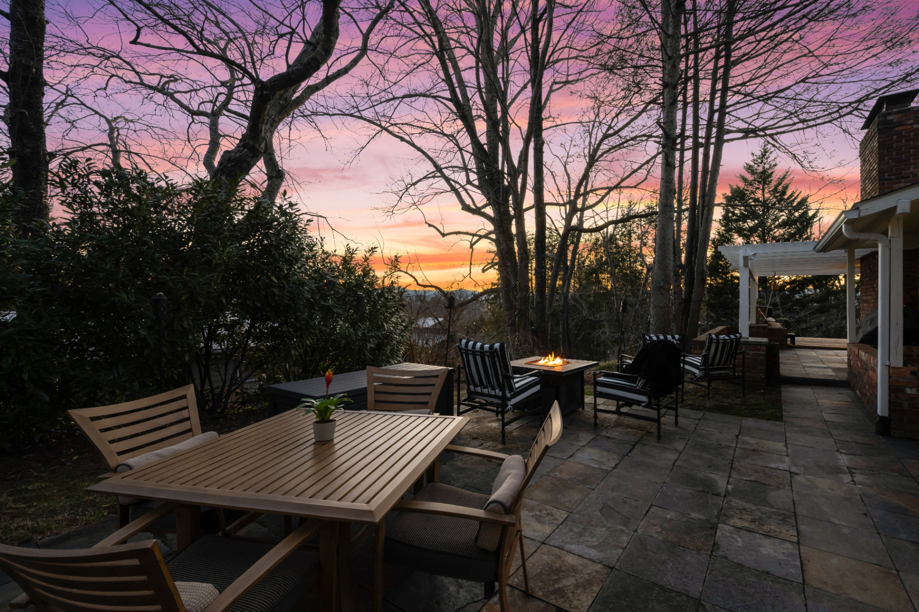 Stone patio with outdoor dining and fire pit at sunset — Asheville intimate gatherings outdoor space