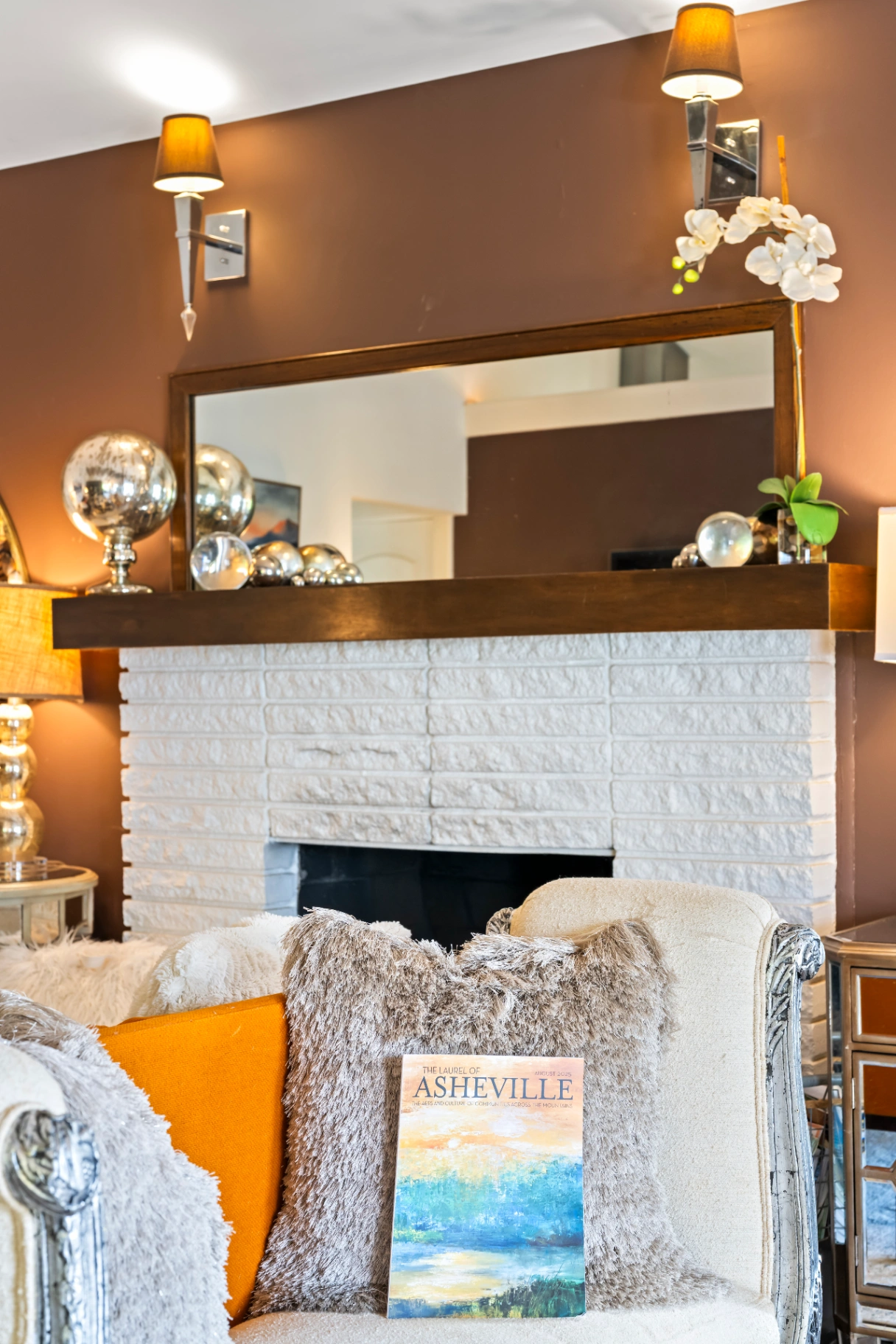 White brick fireplace with decorative mantel and plush pillows — Asheville NC vacation home